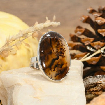 Ring with a brown oval stone on a white background