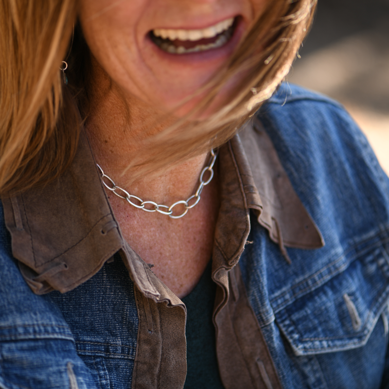 Woman wearing sterling silver oval-link statement chain necklace, close-up worn view