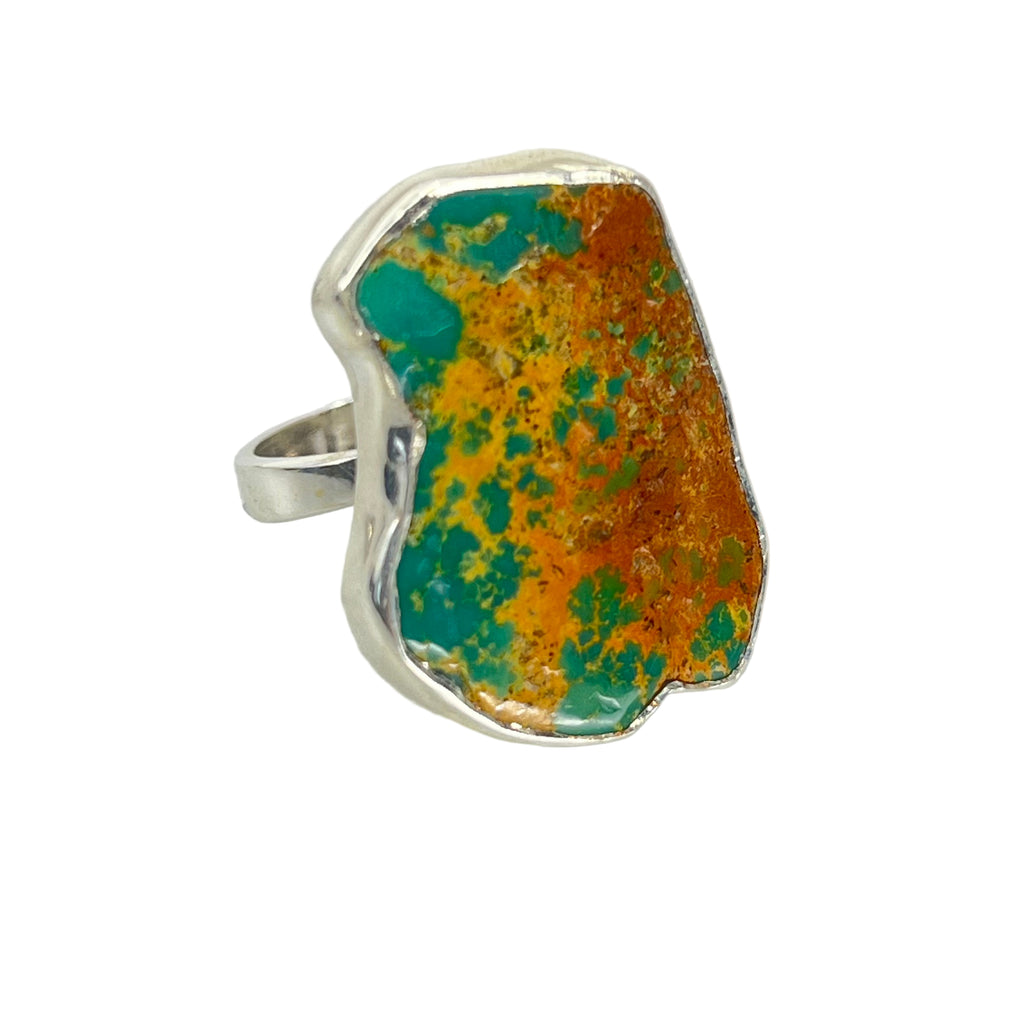 Ring with a large, irregularly shaped stone featuring a mix of turquoise and orange colors on a light gray background.