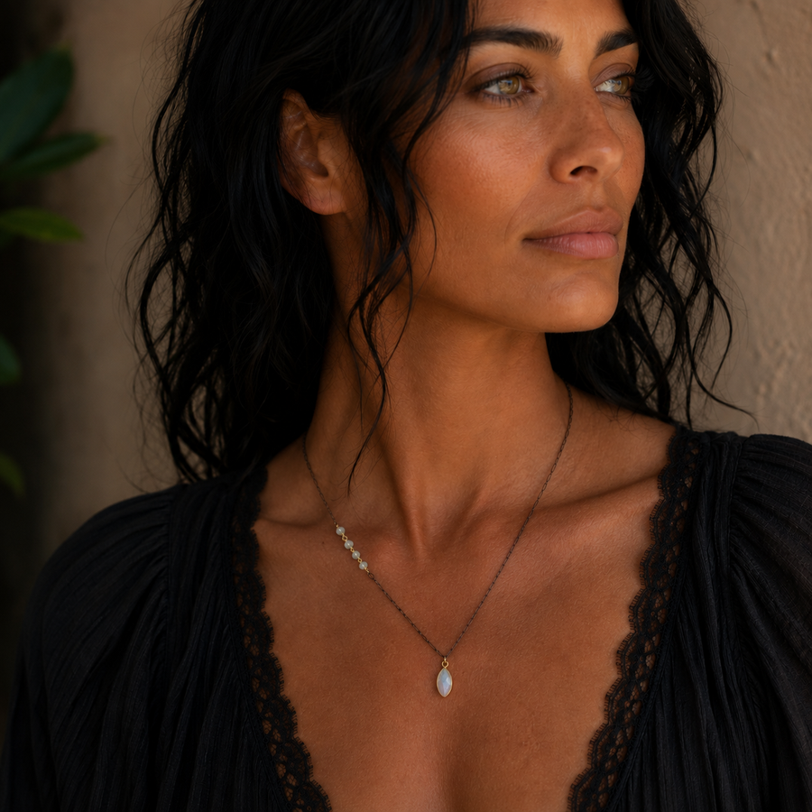 Woman wearing Ethiopian opal beads and opalite pendant on oxidized sterling silver chain with gold vermeil bezel