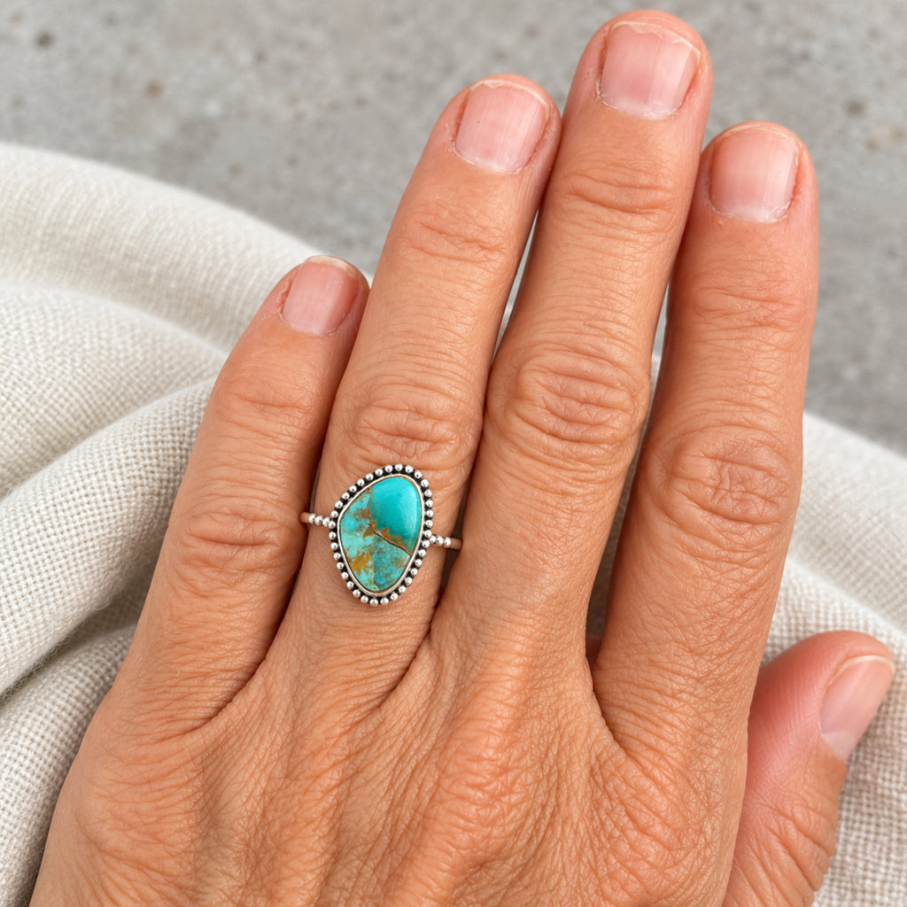 Stabilized Mohave turquoise ring from the Kingman mine, Arizona, in a beaded sterling silver bezel, front product view.