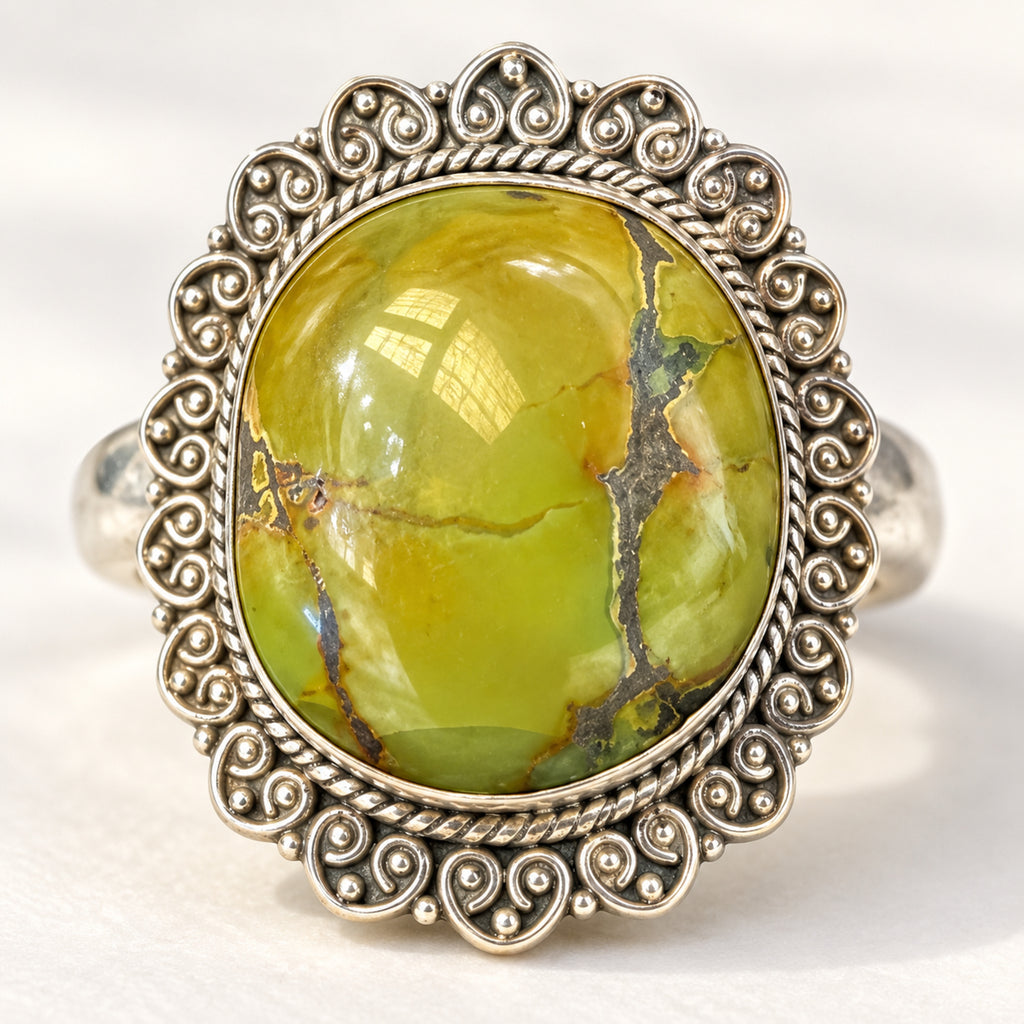 Chartreuse green turquoise ring in a scalloped sterling silver filigree border, front view.