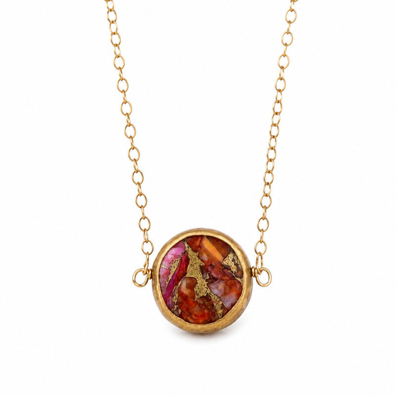 Close-up of pink oyster turquoise in antique brass pendant setting