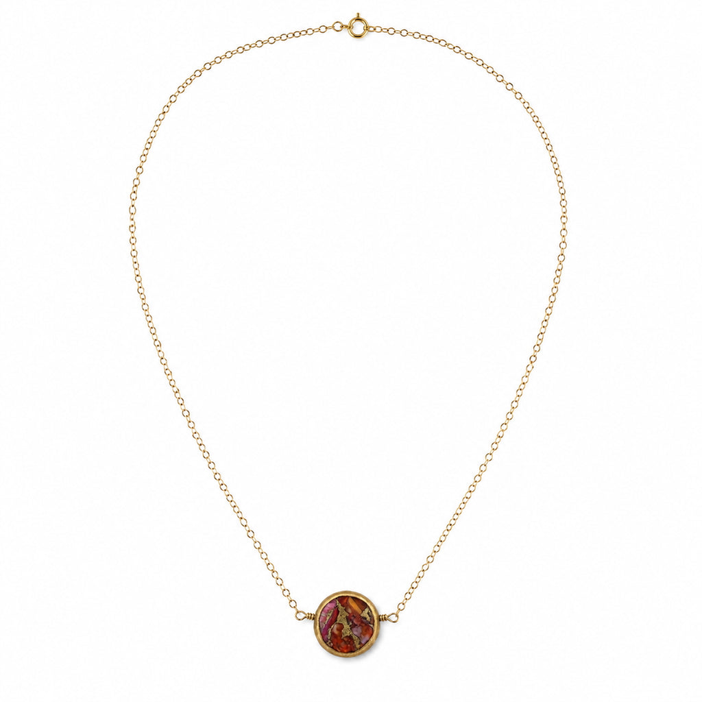 Close-up of pink oyster turquoise in antique brass pendant setting