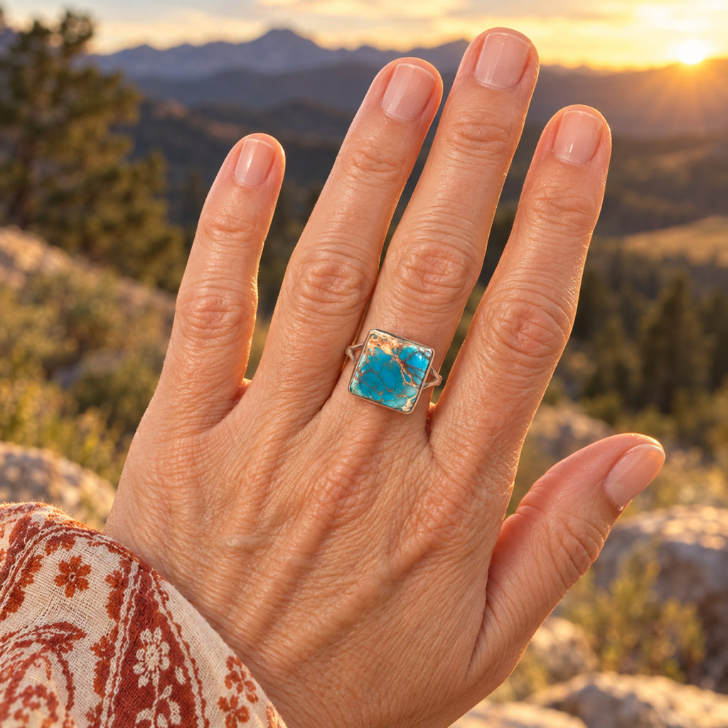 Square sky blue sea sediment jasper ring with copper veining in a sterling silver bezel on a split band, front view