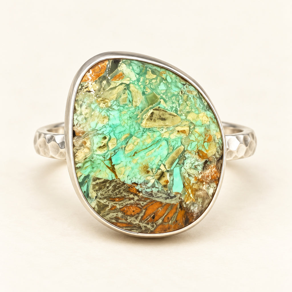 Green smithsonite freeform ring in a tall sterling silver bezel on a hammered adjustable band, front view