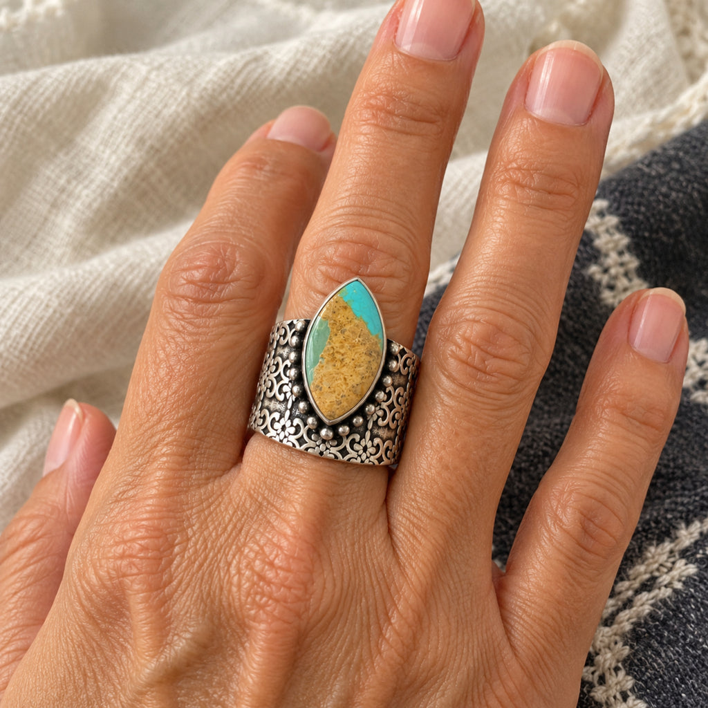 Marquise turquoise with golden matrix on a wide stamped sterling silver band, front view.